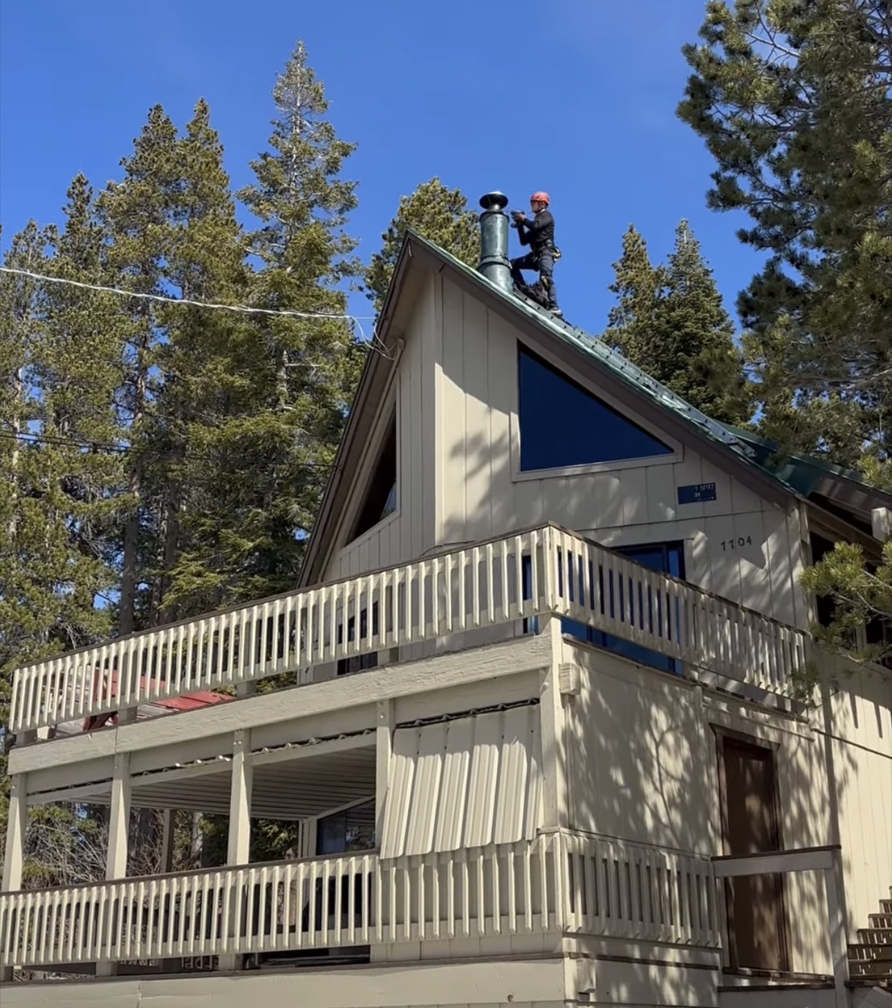 Billy working beside a chimney on a high angle roof